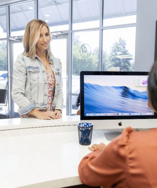 Glass-Orthodontics-New-Patient-Information Patient checking in at orthodontic office front desk in Chesapeake VA serving Elizabeth City NC and Moyock NC at Glass Orthodontics