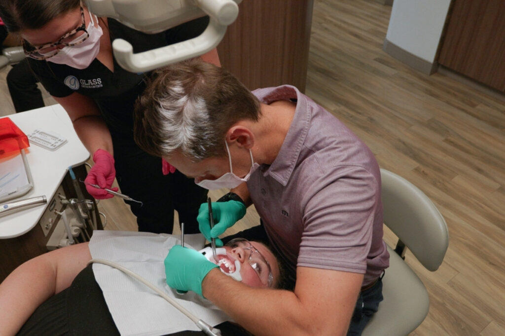 Personalized Braces Treatment Orthodontist placing braces on patient in Chesapeake VA at Glass Orthodontics