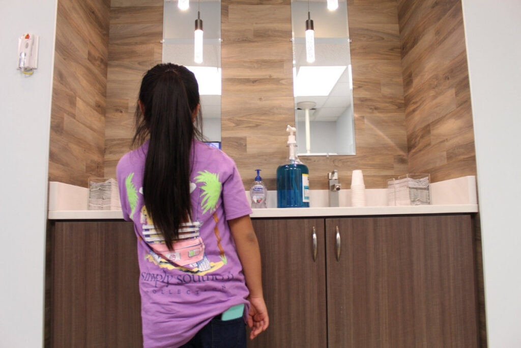 Healthy habits start early Child getting early orthodontic treatment brushing teeth at orthodontic office sink in chesapeake va at glass orthodontics