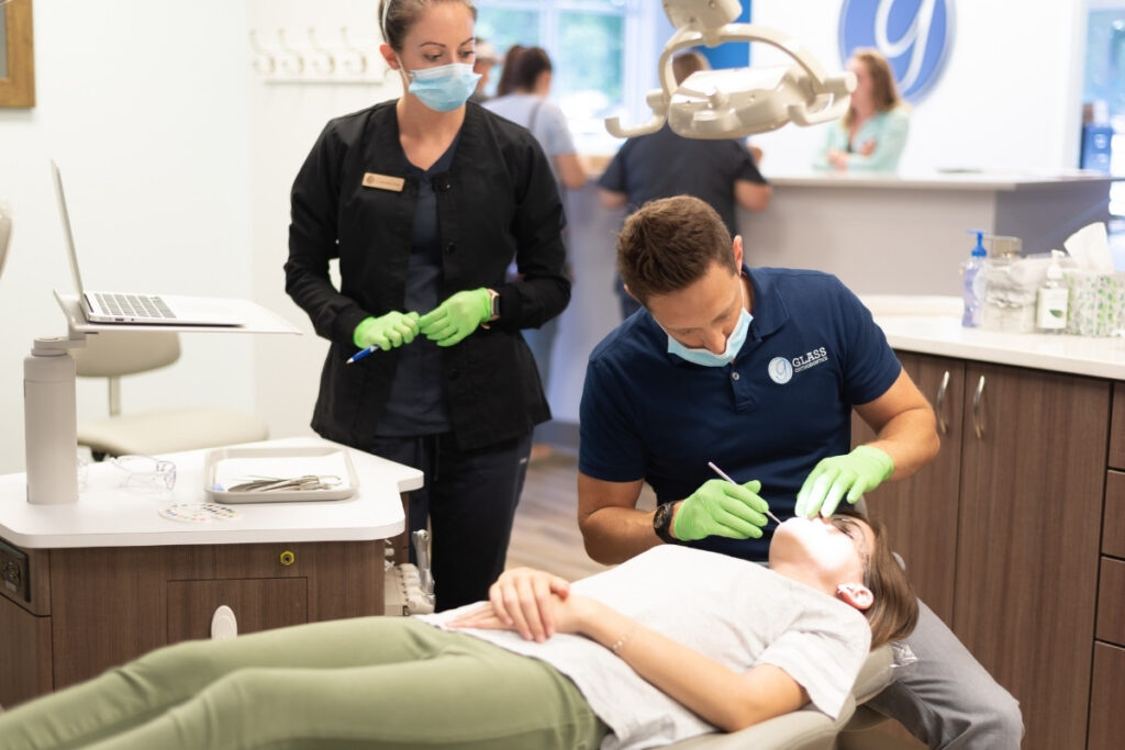 Orthodontic treatment in progress at glass orthodontics Orthodontist performing dental treatment palatal expansion on patient in chesapeake va at glass orthodontics with assistant