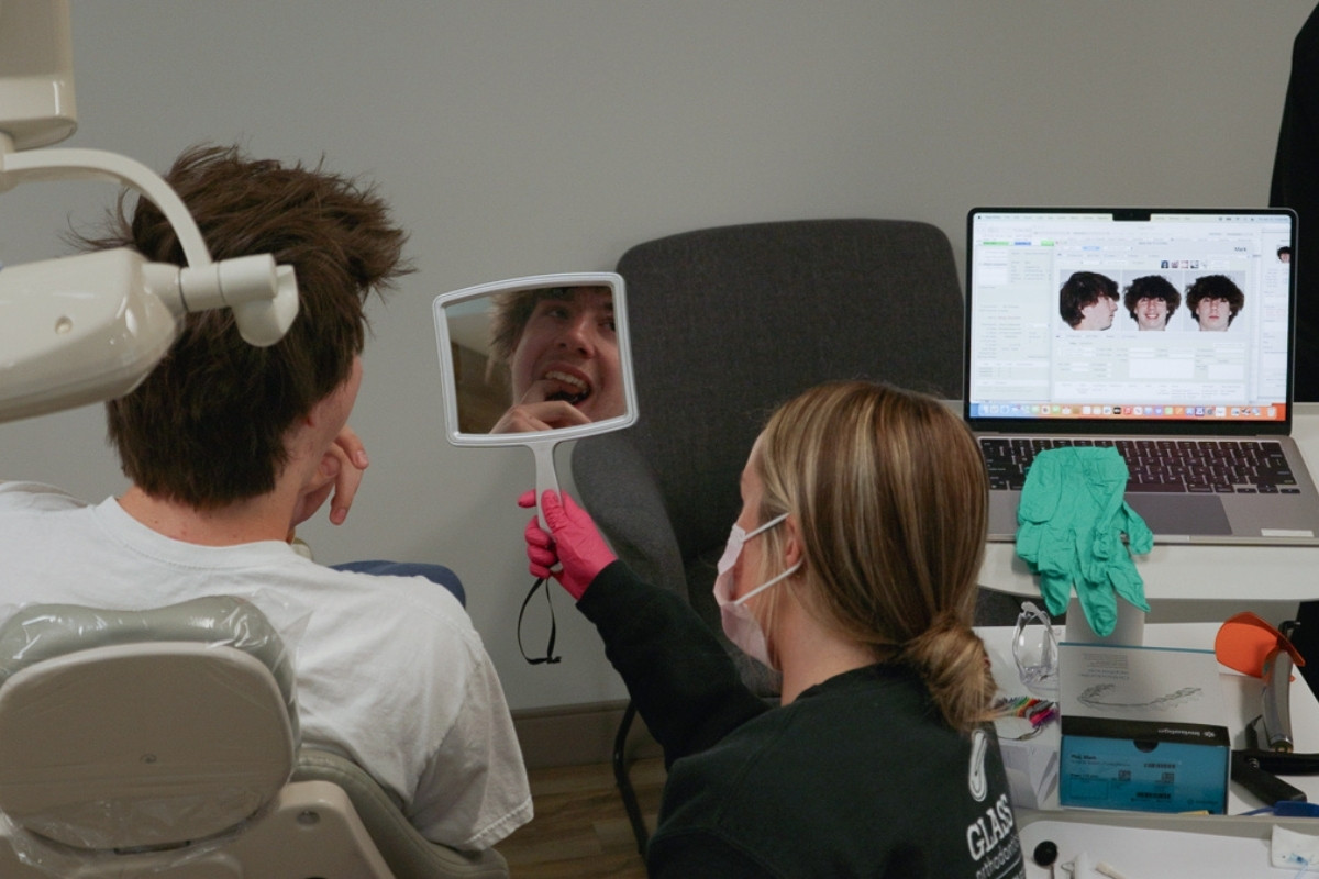 Orthodontic patient reviewing teeth in mirror during consultation in Chesapeake VA at Glass Orthodontics