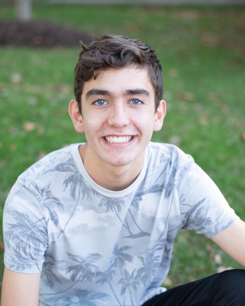 Teen patient smiling outdoors with improved smile after orthodontic care Chesapeake Virginia