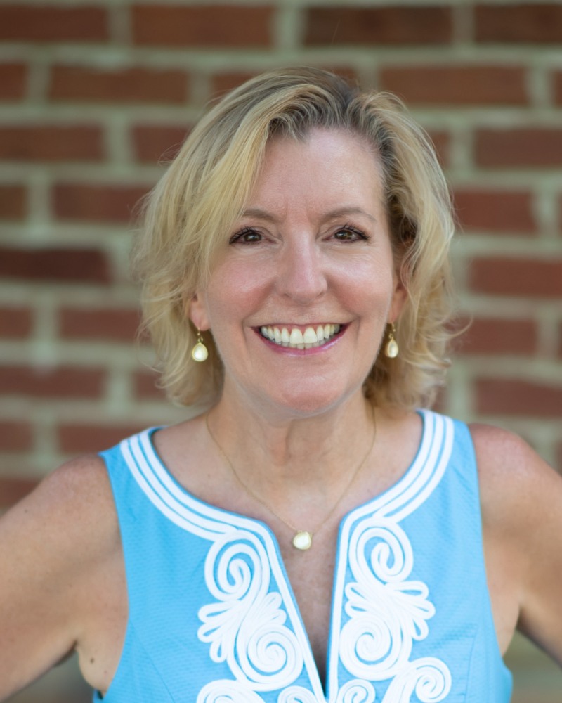 Adult orthodontic patient smiling with straight teeth near brick background in Chesapeake VA