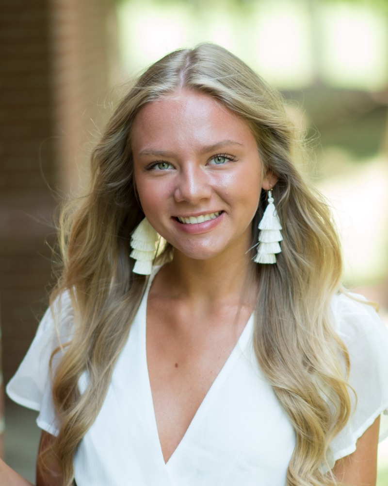 Teen patient smiling after orthodontic treatment outdoors in Chesapeake VA at Glass Orthodontics