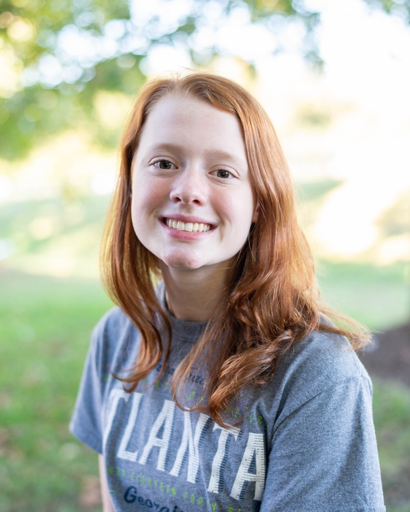 Teen orthodontic patient smiling outdoors with straight teeth in Chesapeake VA