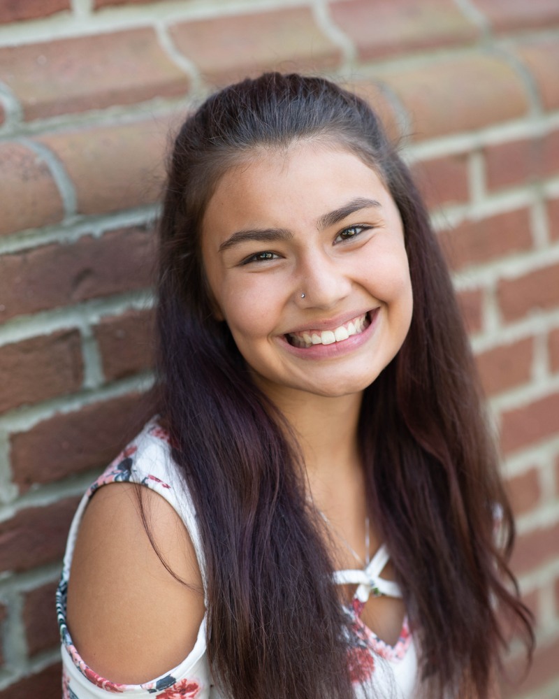 Teen patient smiling outdoors after orthodontic treatment Chesapeake Virginia