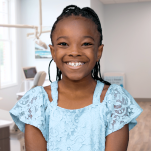 Smiling young girl in an orthodontic office demonstrating healthy teeth and airway, illustrating how orthodontics can help you breathe better.