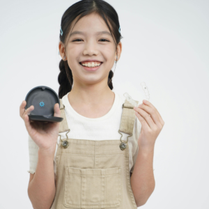 Smiling girl holding clear aligners and case, demonstrating caring for your retainers after orthodontic treatment.